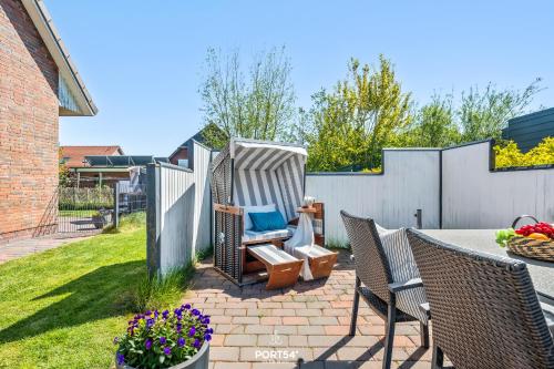 a backyard with a table and chairs and a fence at Ferienwohnung Lee Dagebüll in Dagebüll