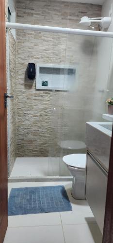a bathroom with a shower with a toilet and a sink at Casa em São Mateus - Guriri in São Mateus