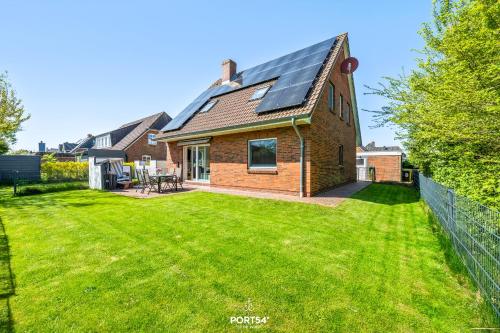 a house with a solar roof on a yard at Ferienwohnung Luv Dagebüll in Dagebüll