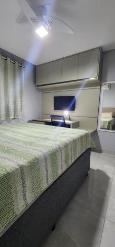a bedroom with a large bed and a television at Casa em São Mateus - Guriri in São Mateus