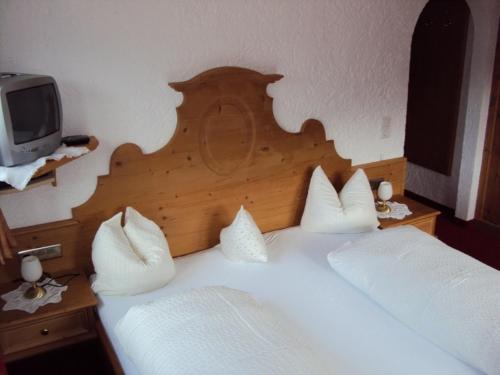 a bedroom with two beds with a wooden headboard and a tv at Fürstenhof in Alpbach