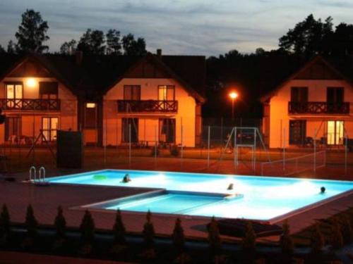 a large swimming pool at night with houses in the background at Apartament Jaśkowy in Żarnowska