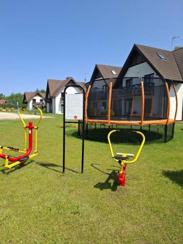 a group of playground equipment in the grass at Apartament Jaśkowy in Żarnowska