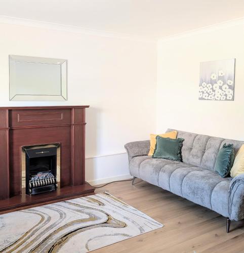 a living room with a couch and a fireplace at Glentorran in Campbeltown