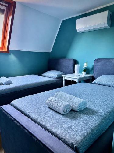 a room with two beds and a blue wall at Apacs Villa in Ráckeve
