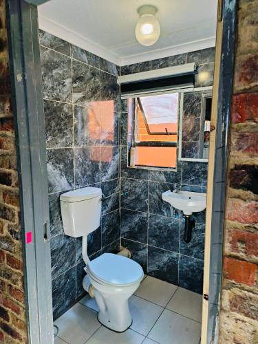 a bathroom with a toilet and a sink at Acasa do Delco Accommodatiion in Welkom