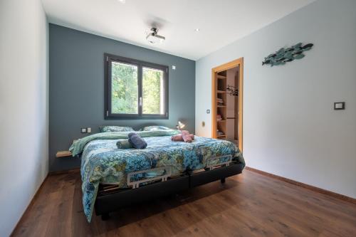 a bedroom with a bed with blue walls and a window at Superbe maison au calme - Piscine in Chantraine