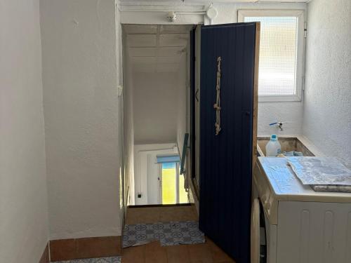 a blue cabinet in a kitchen with a sink at A Beautiful Townhouse with a roof top terrace in Rute