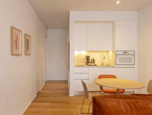 a living room with a table and a kitchen at LSA Estrela by Numa in Lisbon