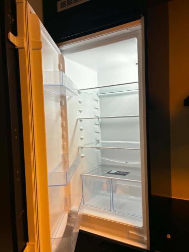 an empty refrigerator with its door open in a room at Bedify Lodge Sokndal in Sokndal