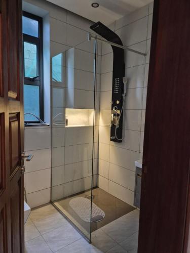 a shower with a glass door in a bathroom at CozyStay Homes in Kampala