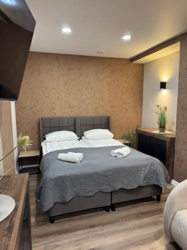 a bedroom with a bed with two towels on it at Sauna Dharma Stay Self check in in Telšiai