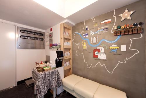 a room with a couch and a wall with a map at Sunny Guesthouse Seoul City in Seoul