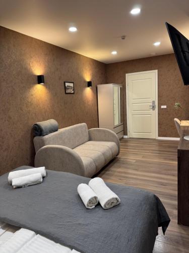 a living room with a bed and a couch at Sauna Dharma Stay Self check in in Telšiai
