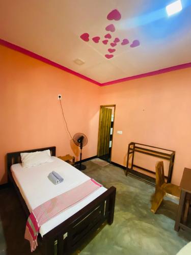 a bedroom with a bed and a ceiling with hearts on it at Super Bistro in Pottuvil
