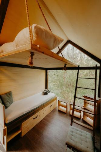 a bedroom with two bunk beds in a tent at Glamping Všímarský potok in Malšín