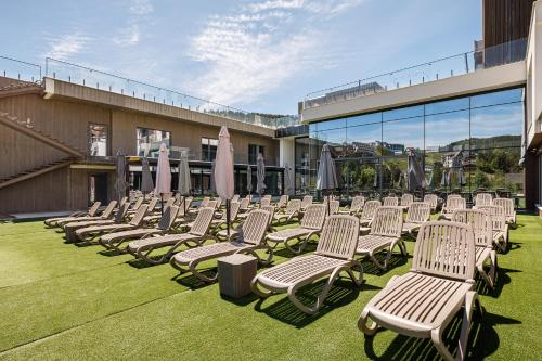a row of lawn chairs with umbrellas on a building at Tavel Hotel & SPA in Bukovel