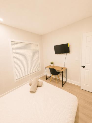 a white bedroom with a bed and a desk at Villa Shores in Miami