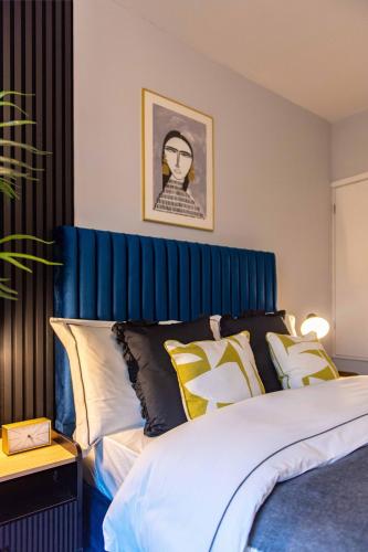a bedroom with a bed with a blue headboard at Central Sheffield Stay, Work Trips, Contractors & City Breaks in Sheffield