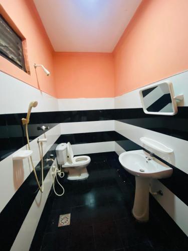 a bathroom with a toilet and a sink at Super Bistro in Pottuvil