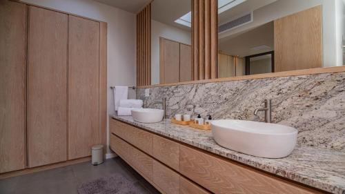 a bathroom with two sinks and a large mirror at Pure Emotions Beach House in Knysna