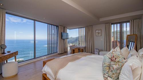 a bedroom with a large bed with a view of the ocean at Pure Emotions Beach House in Knysna