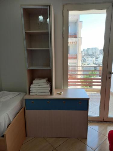 a bedroom with a bed and a dresser with a mirror at Flodril Appartment in Durrës