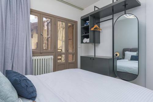 a bedroom with a white bed and a mirror at Maison Montagne Mzaar in Kfardebian