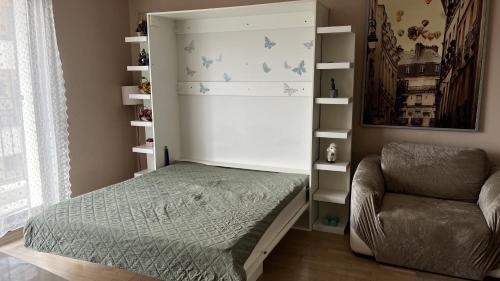 a small bedroom with a bed and a chair at Briz in Varna City