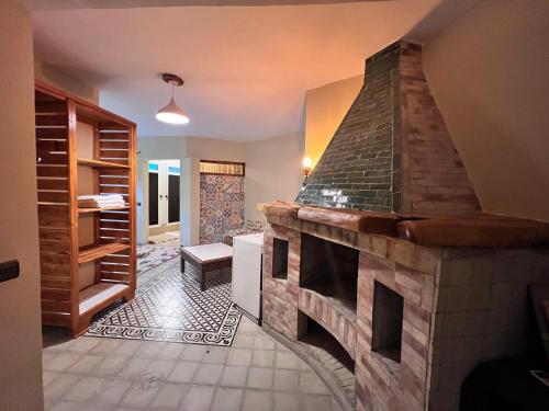 a living room with a stone fireplace in a house at Dar l'eau Vive in Bine el Ouidane