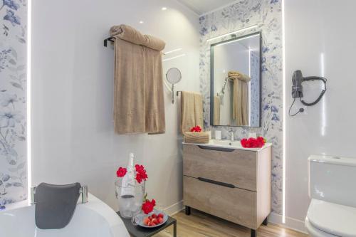 a bathroom with a sink and a mirror at Casa Parque Benavente Conil in Conil de la Frontera