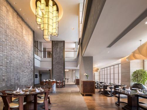a restaurant with tables and chairs and a chandelier at The Mangrovetree Sanya Resort in Sanya