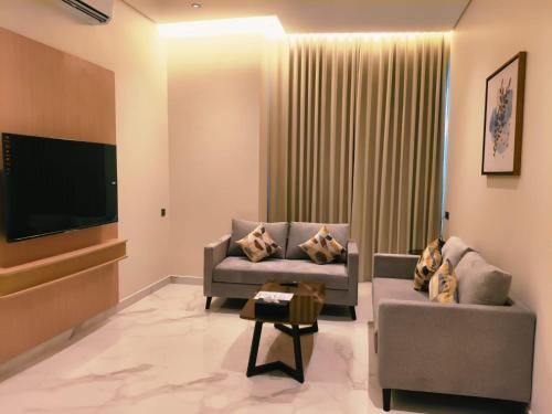 a living room with two couches and a flat screen tv at إليت الجامعة -Elite Served Apartments - Hafar Al-Batin in Hafr Al-Batin