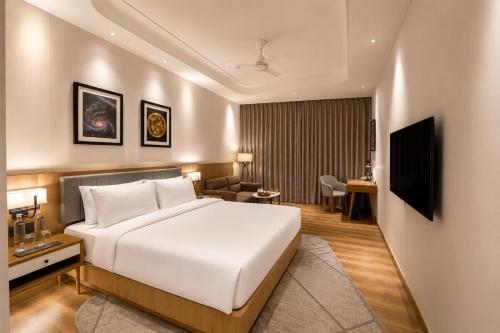 a hotel room with a bed and a living room at Radisson Hotel Nathdwara in Nāthdwāra