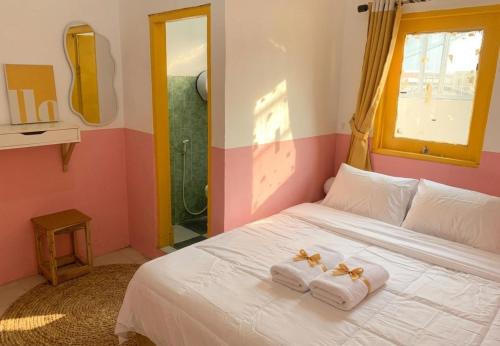 a bedroom with a white bed with towels on it at Decasa Female House in Malang