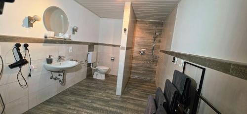 a bathroom with a sink and a toilet and a shower at Ferienhaus am Doctorberg in Bernkastel-Kues