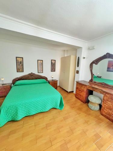 a bedroom with a green bed and a mirror at N'Baz Apartment Lezhë in Lezhë