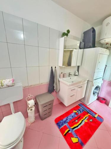 a pink bathroom with a toilet and a sink at N'Baz Apartment Lezhë in Lezhë