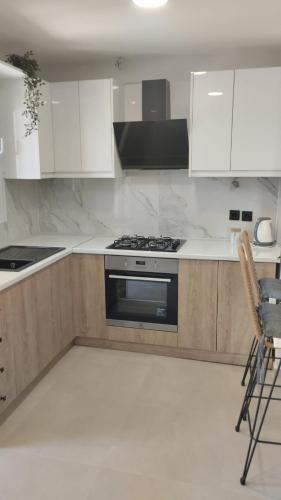 a kitchen with white cabinets and a stove top oven at Ina's apartments in Lefkimmi