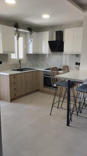 a kitchen with white cabinets and a table and chairs at Ina's apartments in Lefkimmi