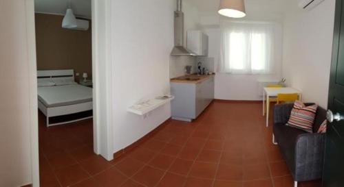 ein Zimmer mit Küche und ein Wohnzimmer mit Sofa in der Unterkunft Bambù Affittacamere & Residence in Teramo