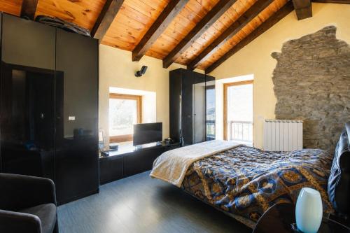 a bedroom with a bed and a stone wall at The Old Barn by Roby in Saint Vincent