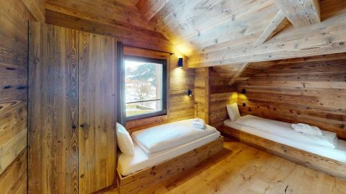 two beds in a log cabin with a window at Chalet Dents Blanches - Latitude Champéry in Champéry