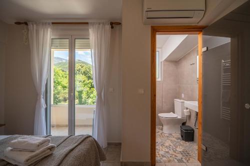 a bedroom with a bed and a bathroom with a window at Villa 4 DESTINA in Élos