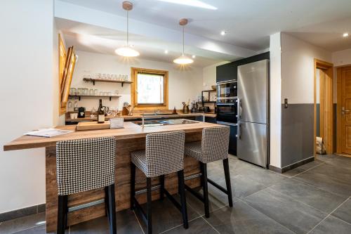 a kitchen with a large island with bar stools at Chalet Nanouk - exposé plein sud in La Salle-les-Alpes