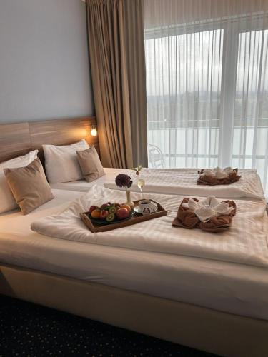 a hotel room with two beds with a tray of fruit on it at Kurhotel Pyramide Sibyllenbad in Neualbenreuth