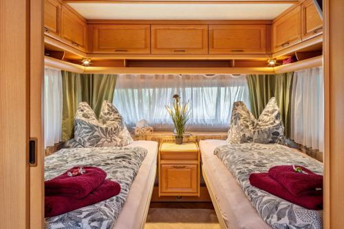 two beds in a small room with a window at La Pura Vida - Glamping in Brandenburg an der Havel