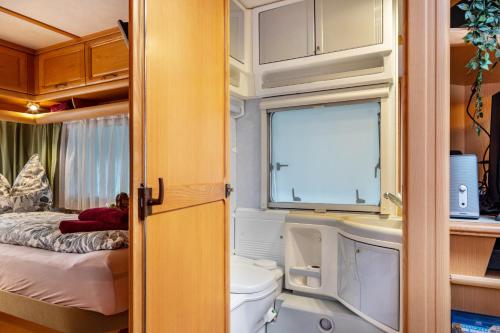 a small bathroom with a toilet and a bed at La Pura Vida - Glamping in Brandenburg an der Havel