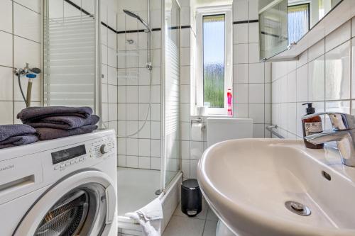 a bathroom with a washing machine and a sink at Ferienwohnung Halde Hoheward in Recklinghausen