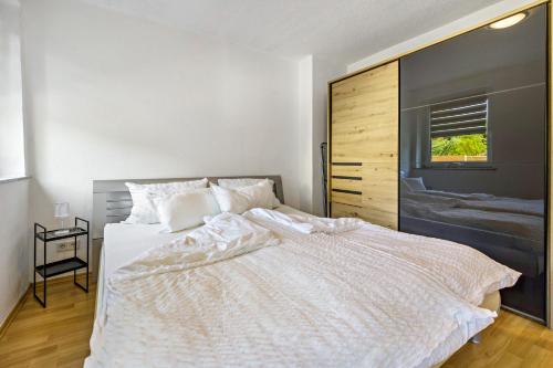 a bedroom with a large white bed with a window at Ferienwohnung Halde Hoheward in Recklinghausen